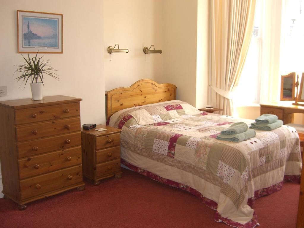 a bedroom with a bed and a dresser and a bed sidx sidx sidx sidx at Stavordale House in Weymouth