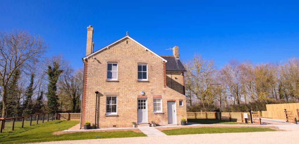 an old brick house with two chimneys at Longstowe Farmhouse in Longstowe