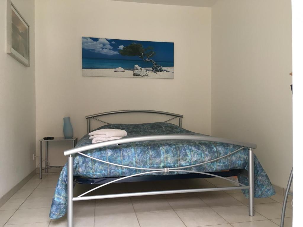 a bed in a room with a picture on the wall at Chambre du verger in Francheville