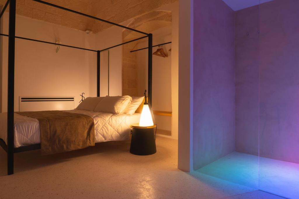 um quarto com uma cama de dossel e um candeeiro em Donna Domenica Boutique Suites em Polignano a Mare