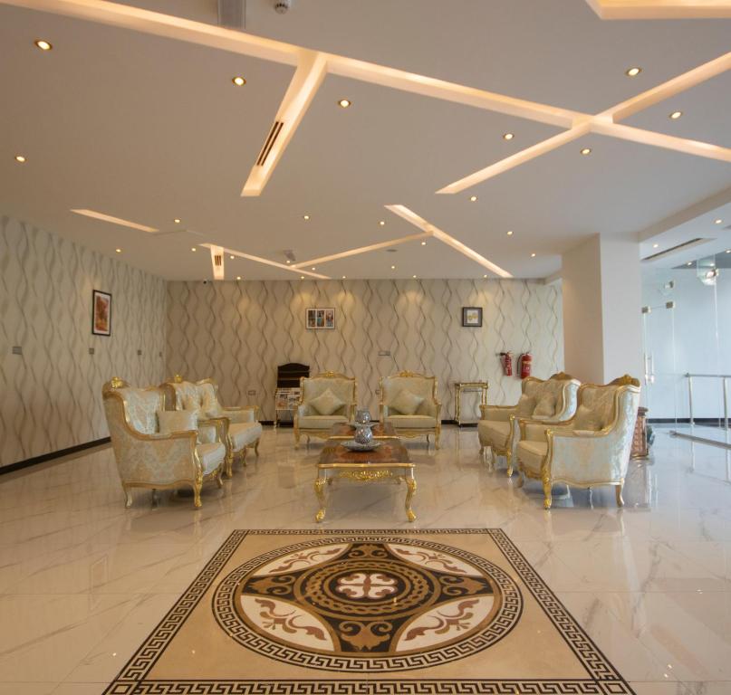 a lobby with chairs and a table and a rug at Home Station Hotel in Muscat