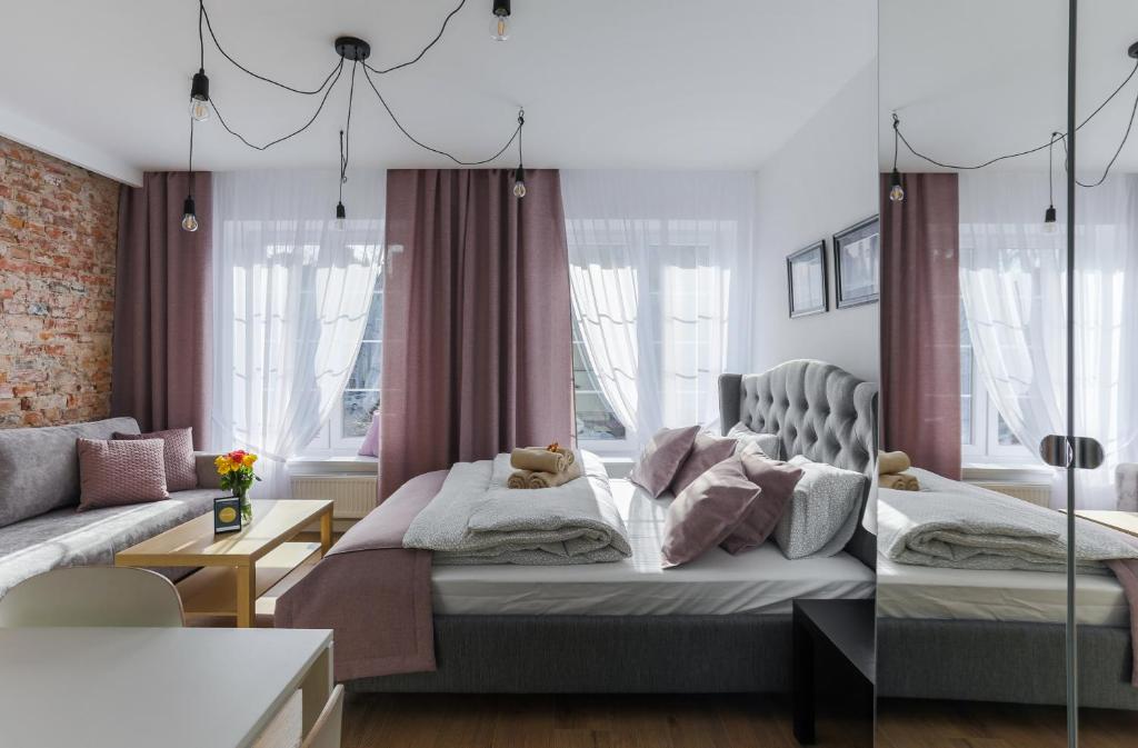 - une chambre avec un lit et un canapé dans l'établissement Central Apartments Piwna, à Gdańsk