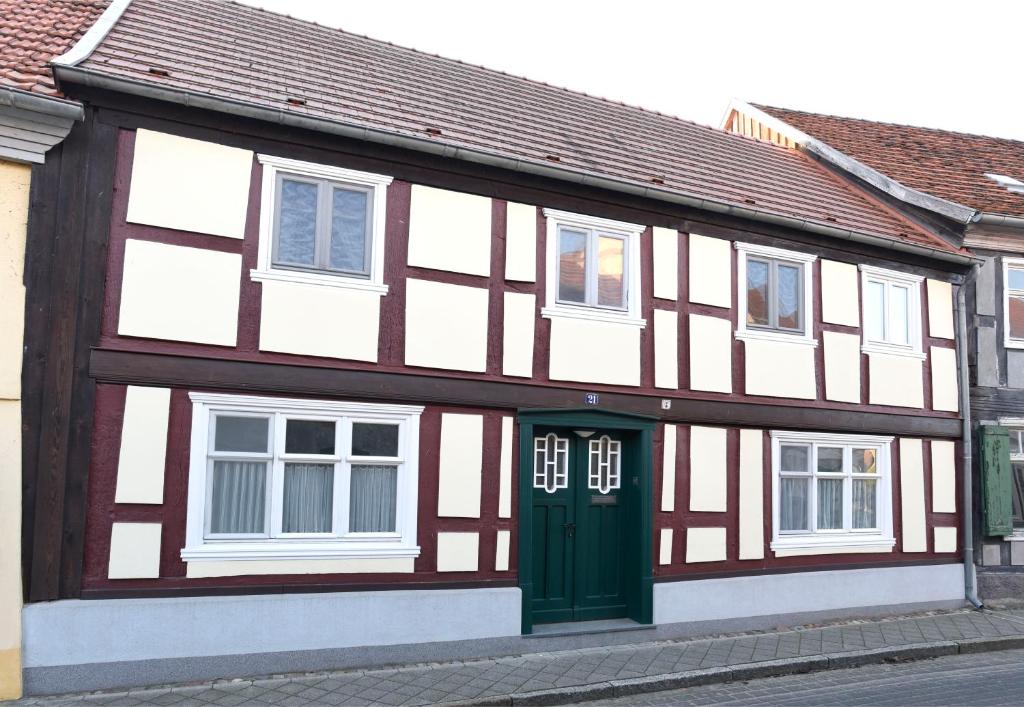 a building with a green door on a street at Haus Löcknitz - Ferienhaus in Lenzen (Elbe) in Lenzen