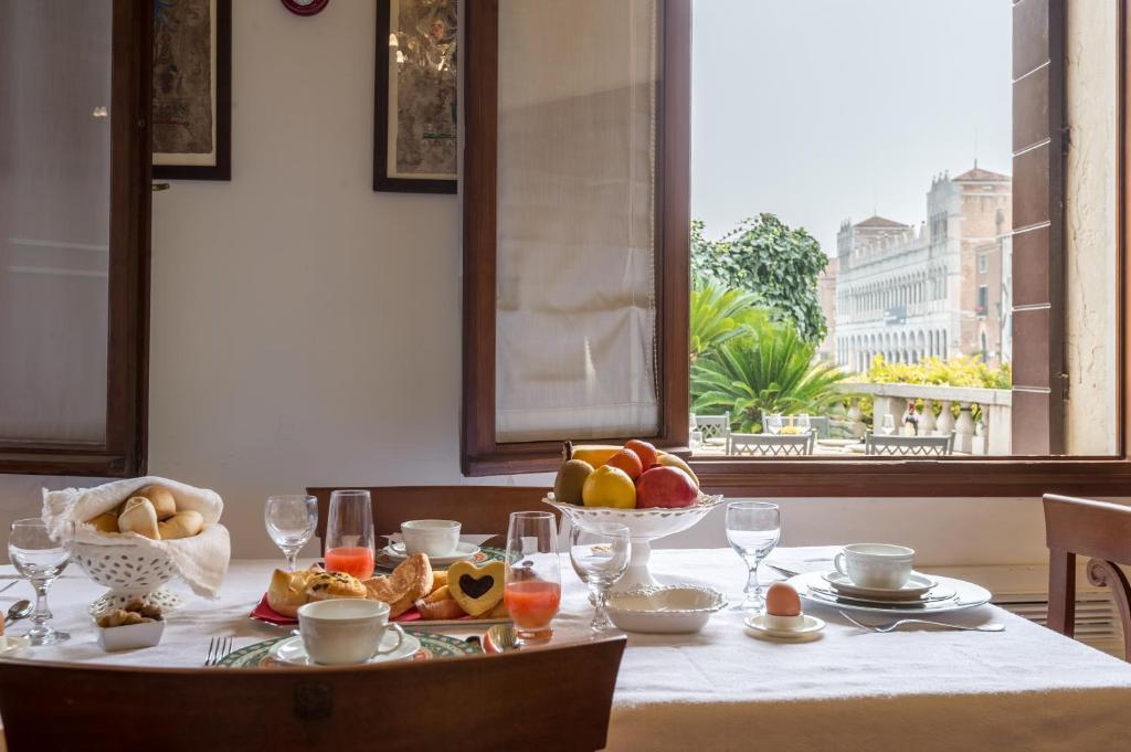 einen Tisch mit einer Schale Obst und einem Teller Essen in der Unterkunft Ca' dei Cuori on the Grand Canal in Venedig