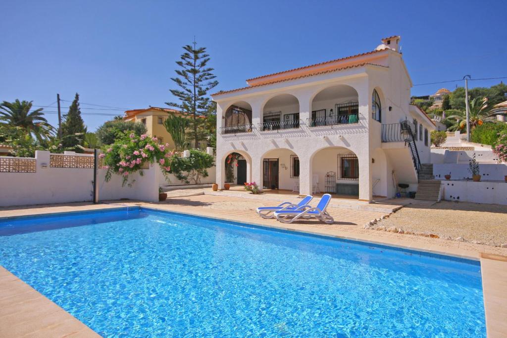 a villa with a swimming pool in front of a house at Villa Roel in Calpe