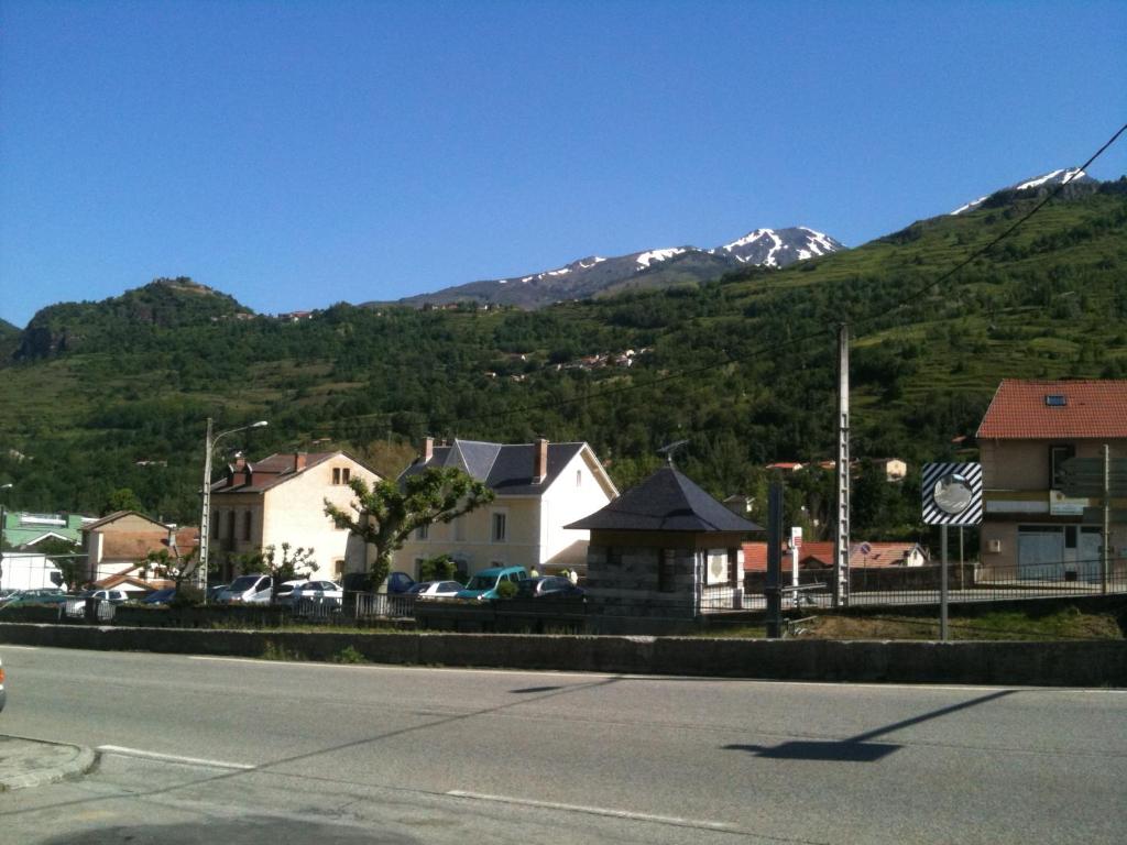 a small town with a mountain in the background at Hôtel de la Paix in Luzenac