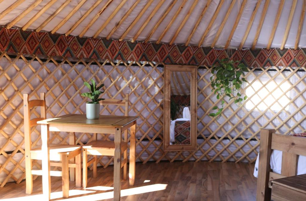 a room with a table and chairs in a yurt at Meadow Vale Retreats in Screveton
