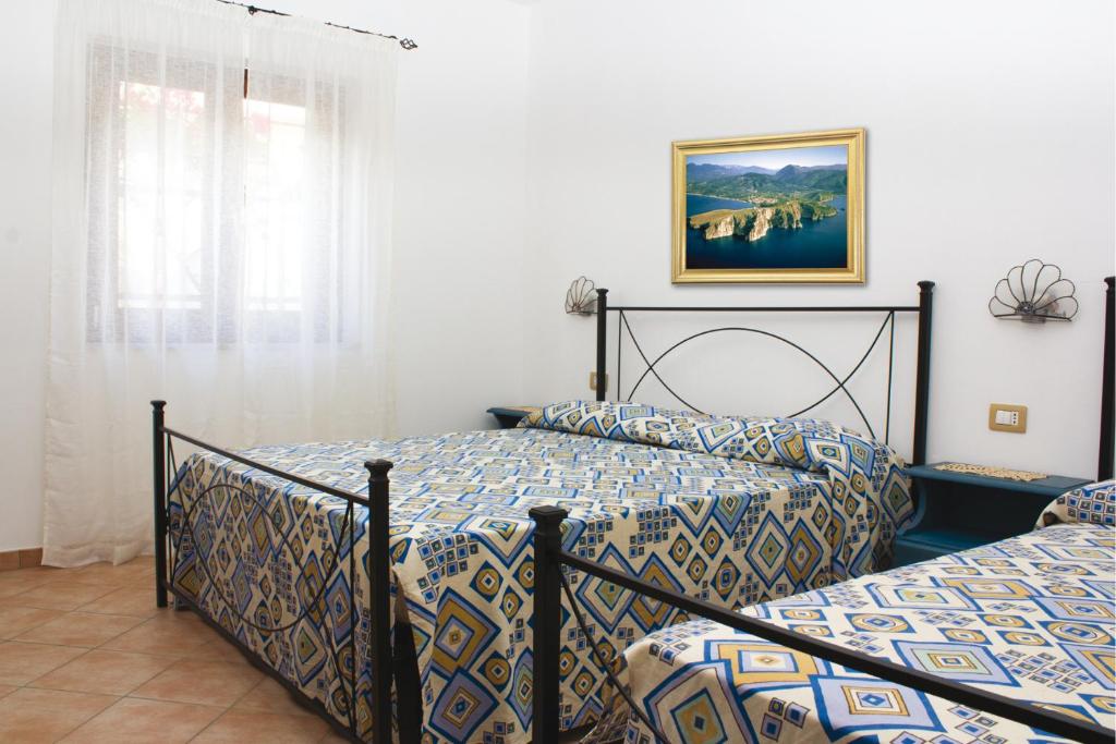 a bedroom with two beds and a picture on the wall at Residence Il Casale in Caprioli