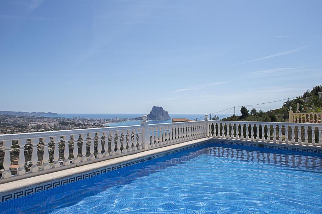 a swimming pool on a balcony with a view of the ocean at Villa Anuska - Plusholidays in Calpe
