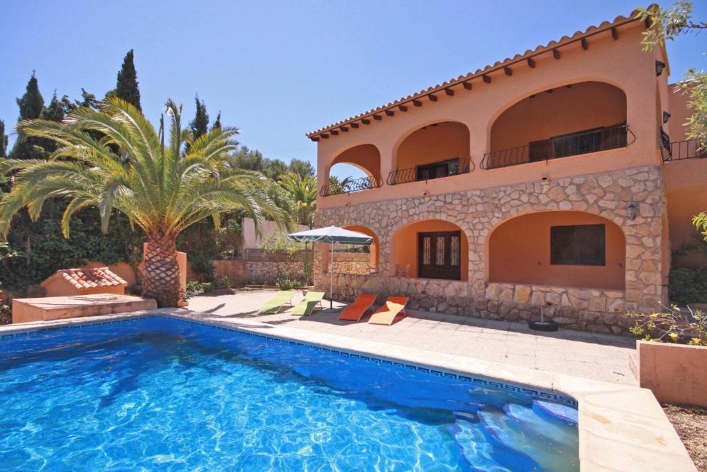 a villa with a swimming pool in front of a house at Villa Marifina in Benissa