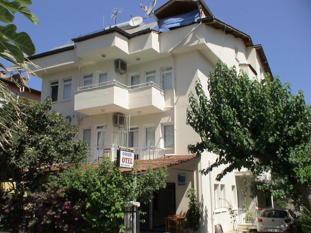 un gran edificio blanco con un cartel delante en Onur Pension, en Fethiye