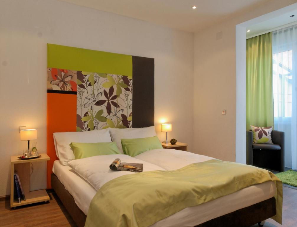 ein Schlafzimmer mit einem großen Bett mit einem Buch darauf in der Unterkunft Schlotzeria Hotel I Café I Eis in Grenzach-Wyhlen