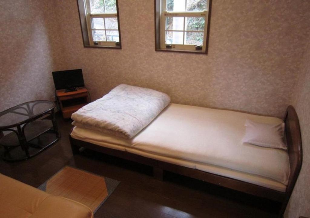 1 dormitorio con 1 cama, 1 mesa y 2 ventanas en GuestHouse StrawberryFarm Shirasaki-Ⅱ / Vacation STAY19358, en Ōbiki