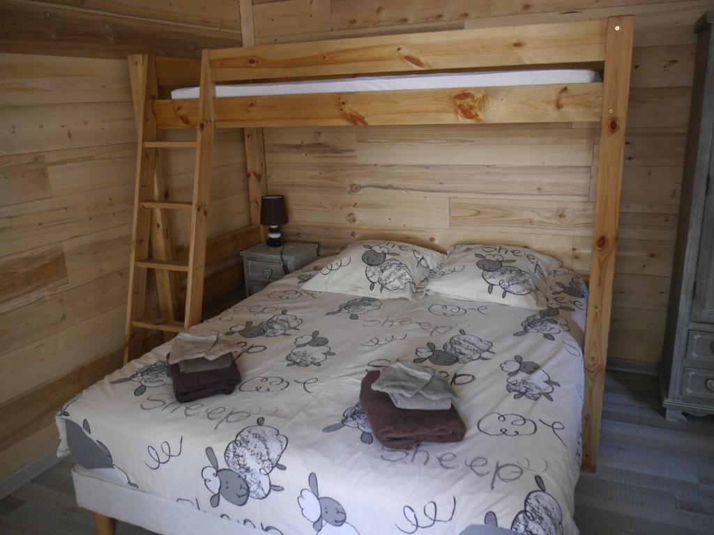 a bed in a wooden room with a bunk bed at STUDIO COSY LE ROYAL SKI 3 VALLÉES in Brides-les-Bains