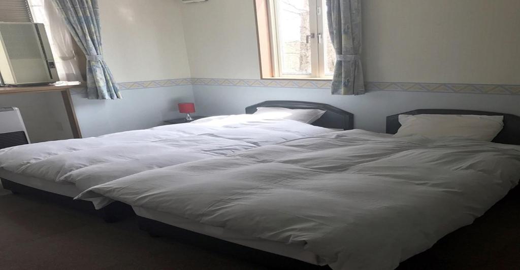 a large white bed in a bedroom with a window at Myoko - Hotel / Vacation STAY 17051 in Myoko