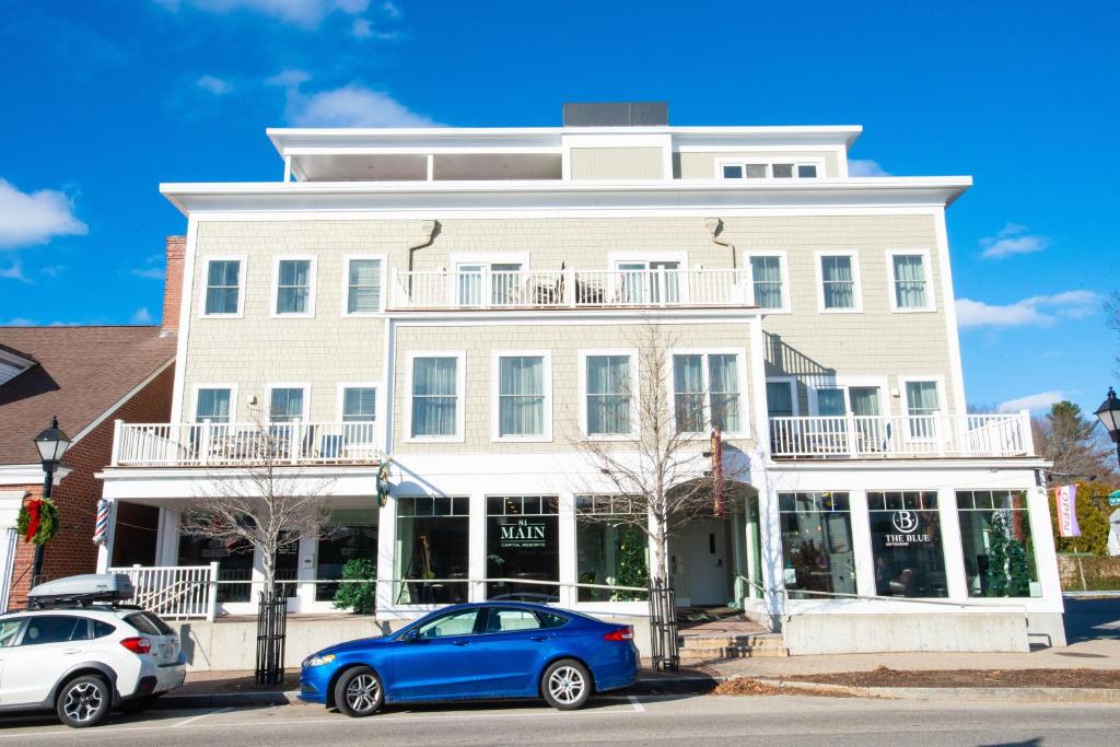 a white building with cars parked in front of it at 84 Main by Capital Vacations in Kennebunk