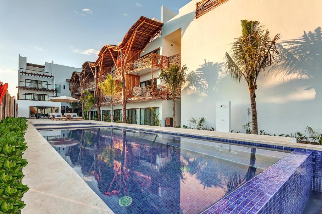 a large swimming pool in front of a large building at Mystique Holbox by Royalton, A Tribute Portfolio Resort in Holbox Island