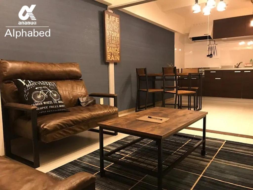 - un salon avec un canapé et une table dans l'établissement Alphabed Takamatsukouzaiekimae 102 / Vacation STAY 20340, à Takamatsu