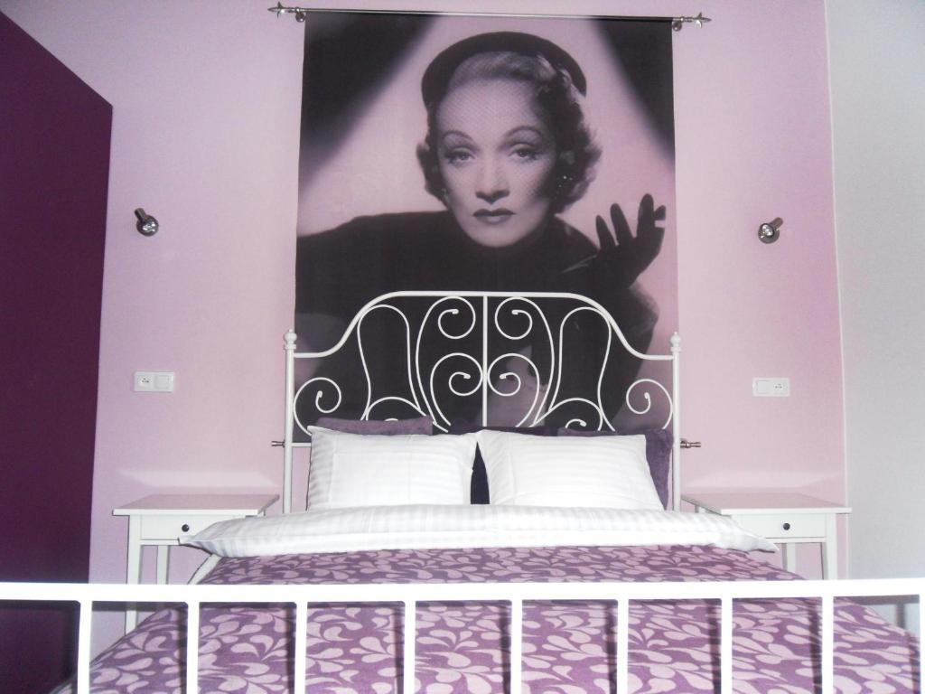 a bedroom with a poster of a woman on the wall at Apartamenty Lili & Country in Krakow