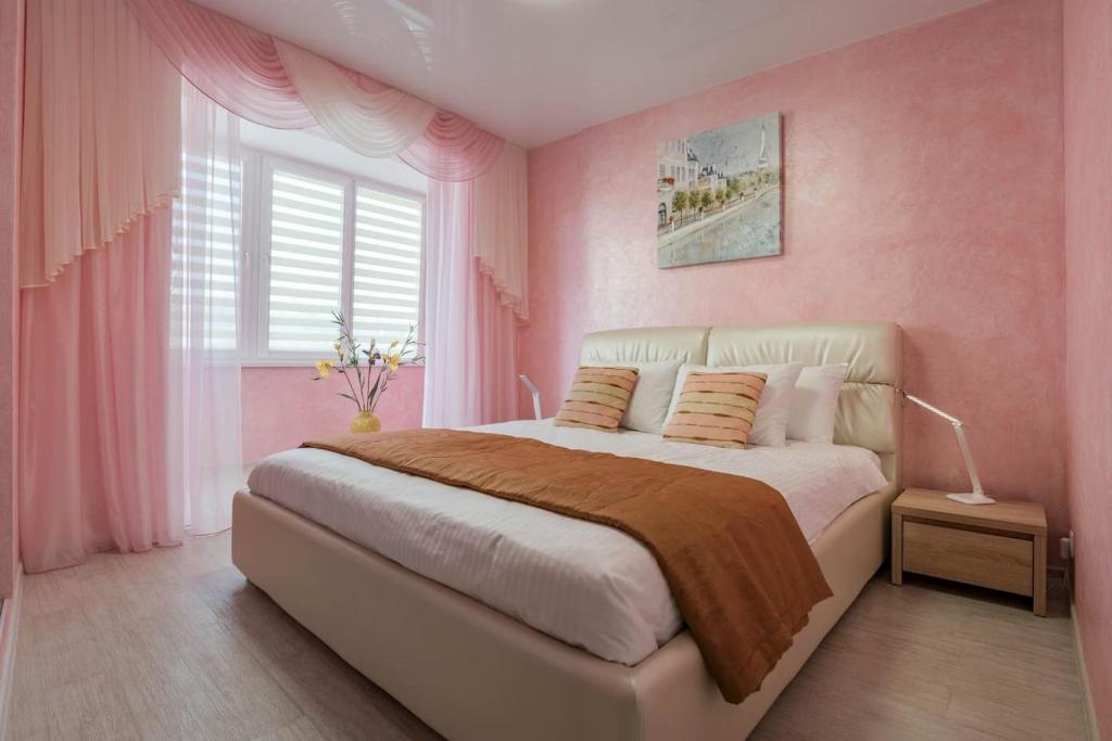 a bedroom with pink walls and a large bed at 2-room Apartment Lux near Centre Wi-Fi Free in Dnipro