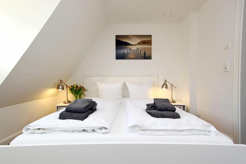 a bedroom with a white bed with two pillows on it at Haus-Clara in Hörnum