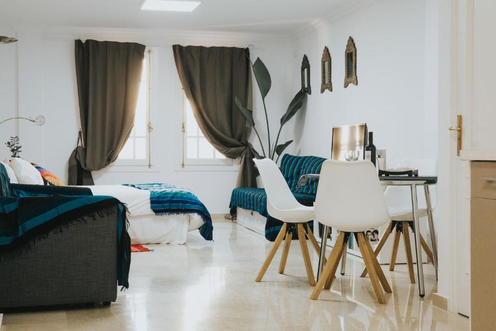 een slaapkamer met een bed, een bureau en 2 witte stoelen bij Home Bassou in Santa Cruz de Tenerife