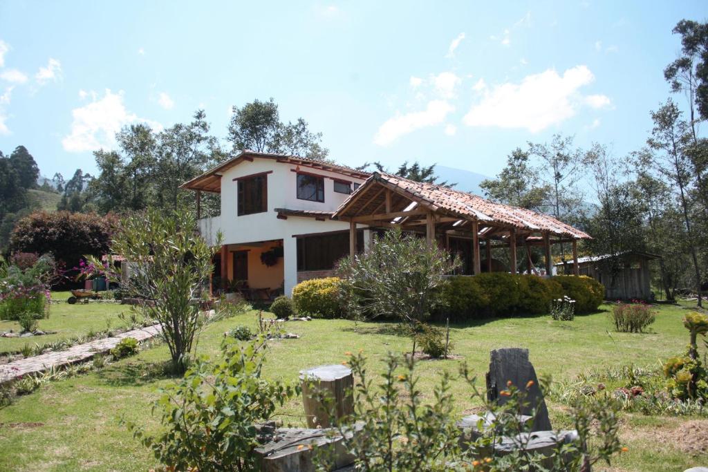 a house with a garden in front of it at Monte Verde Cabañas y Camping in Arcabuco