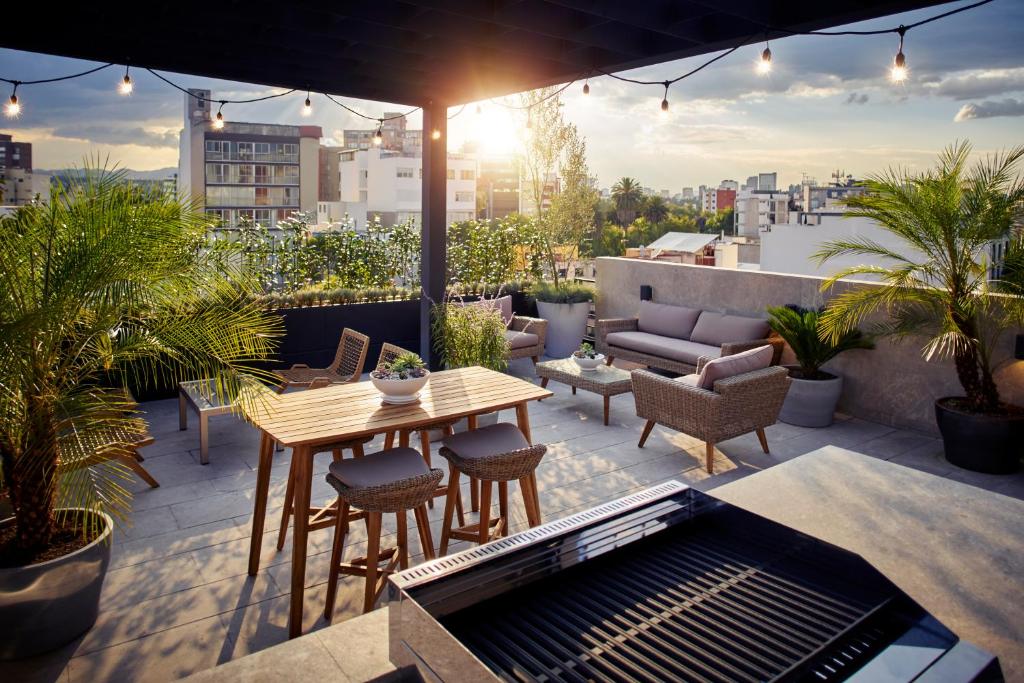 a patio with a table and chairs on a rooftop at Felix Luxury Plus by Viadora in Mexico City
