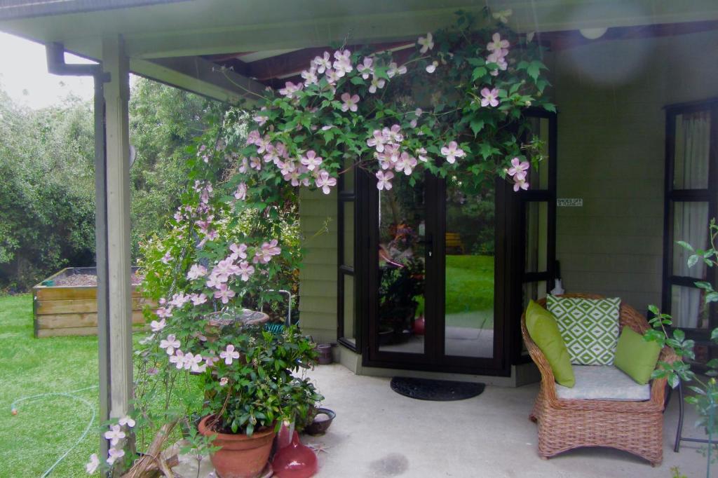 a pergola with pink flowers on a patio at Oldfields in Geraldine
