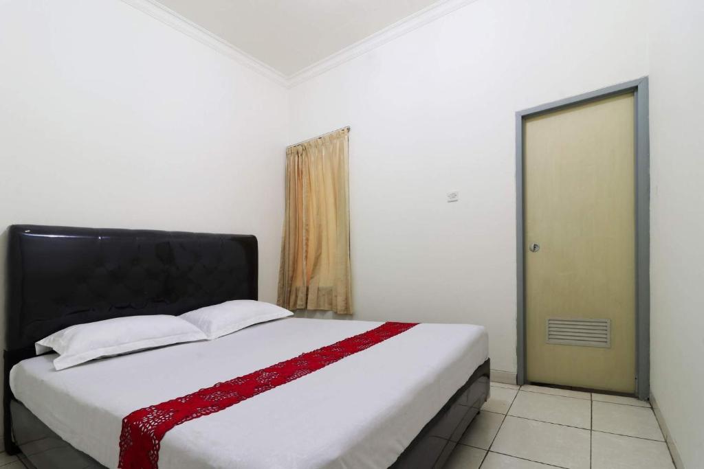 雅加達的住宿－Wisma Lamida 2 Syariah，一间卧室配有一张带红白毯子的床