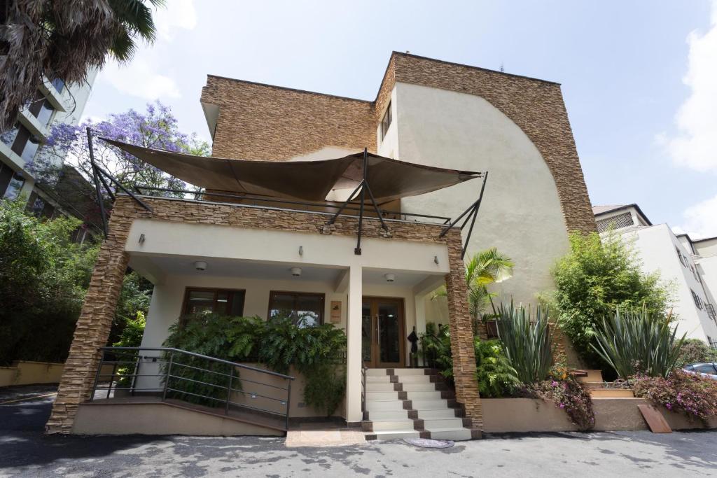a house with an umbrella on the front of it at Reata Apartment Hotel in Nairobi