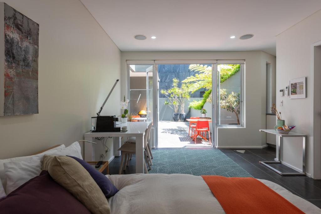 a bedroom with a bed and a desk and a door at Stunning Views To Beat Lockdown Blues in Sydney