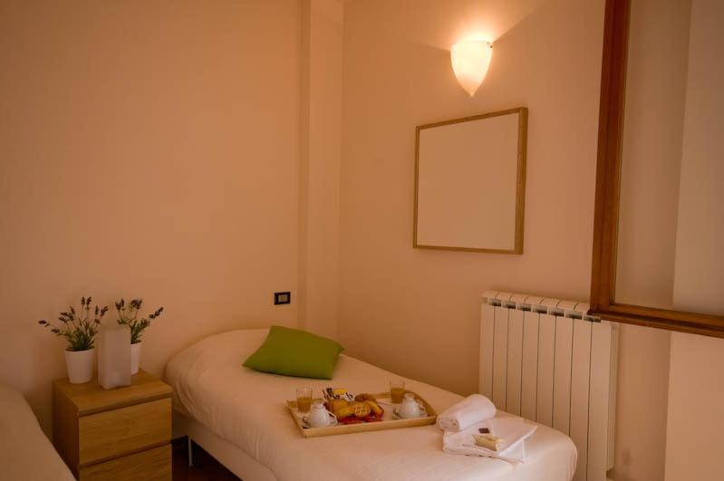 Dormitorio pequeño con cama y espejo en Dormire a Cisanello, en Pisa