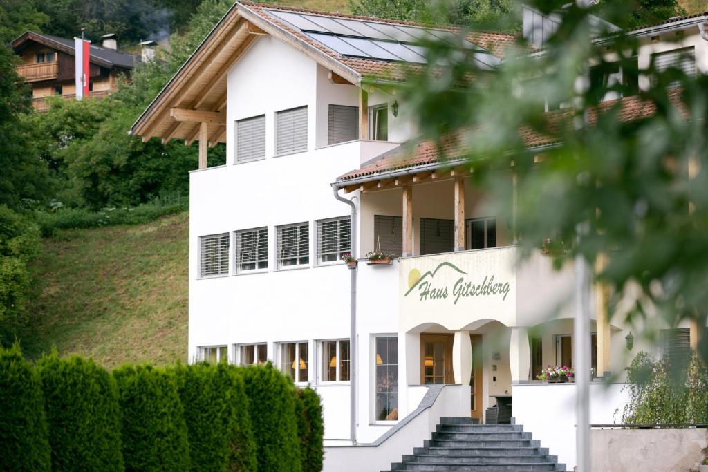 Ein weißes Gebäude mit einem Schild drauf. in der Unterkunft Gitschberg - Appartements in Vintl