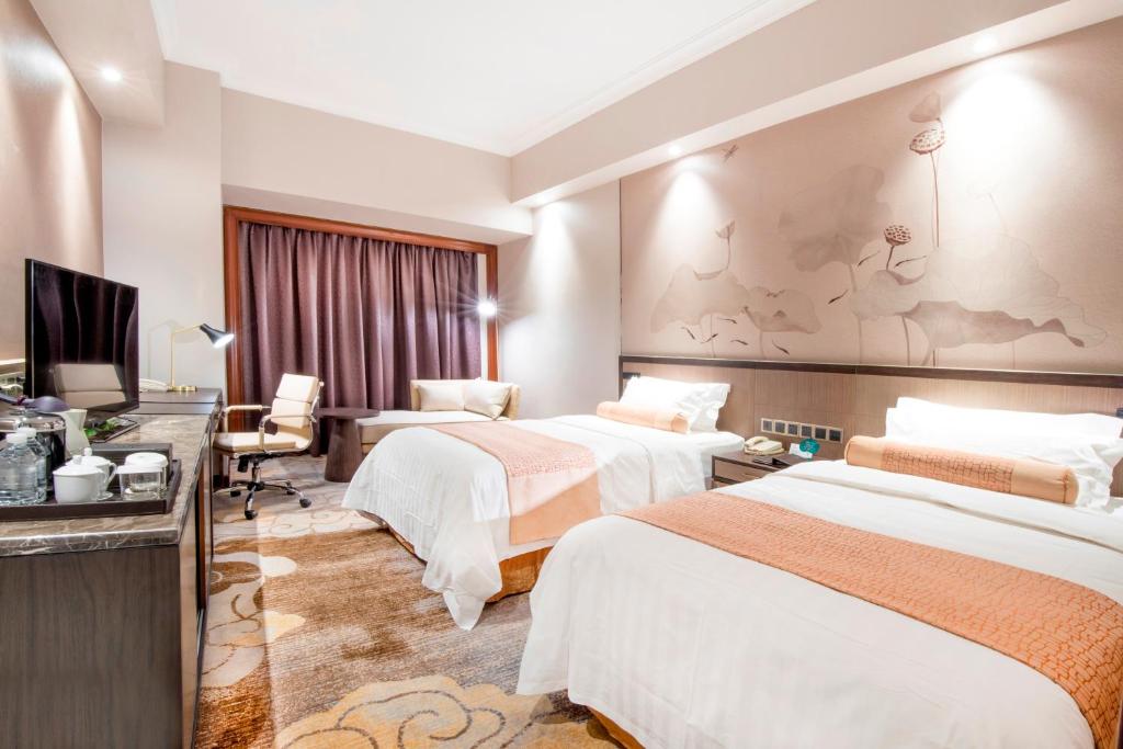 Postel nebo postele na pokoji v ubytování Jin Jiang Pine City Hotel
