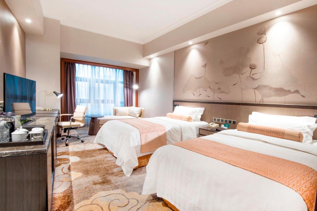Postel nebo postele na pokoji v ubytování Jin Jiang Pine City Hotel