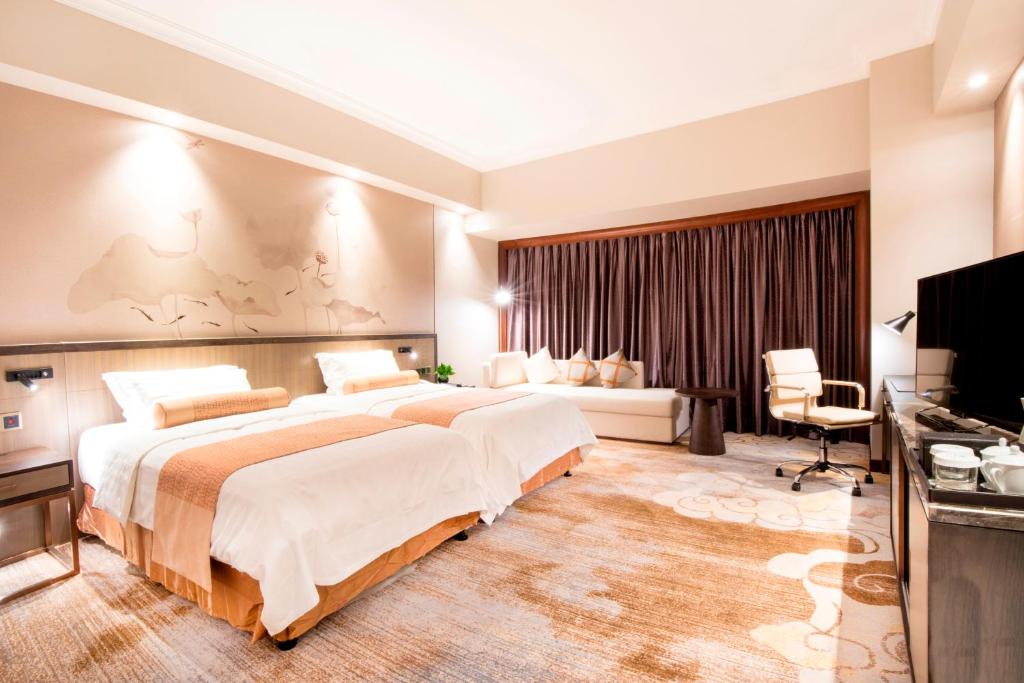 Postel nebo postele na pokoji v ubytování Jin Jiang Pine City Hotel