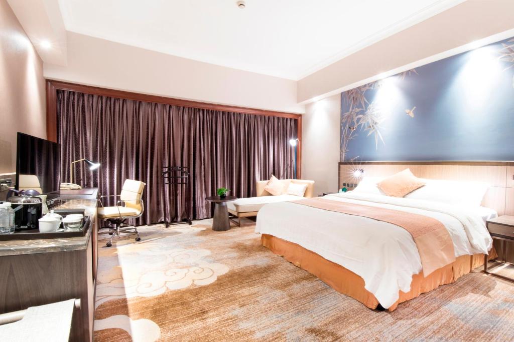 Postel nebo postele na pokoji v ubytování Jin Jiang Pine City Hotel
