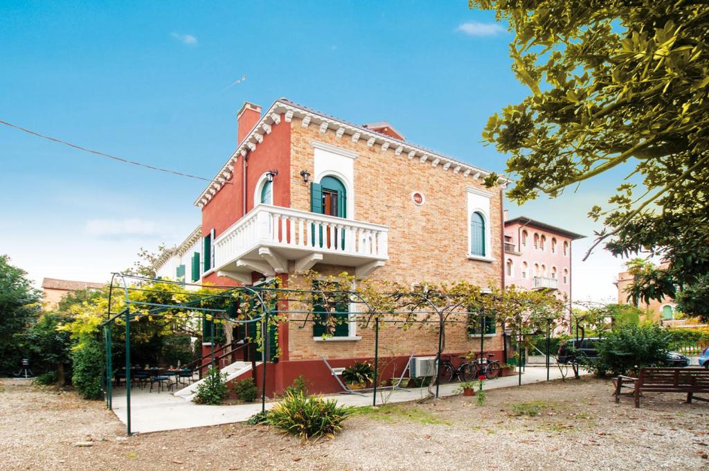 - un bâtiment en briques avec un balcon au-dessus dans l'établissement Villa Contarini B&B, sur le Lido de Venise