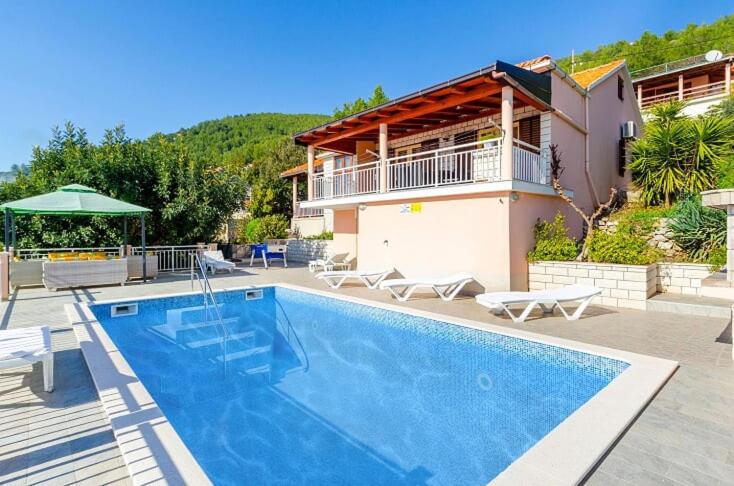 a swimming pool in front of a house at Vila petra in Prizba