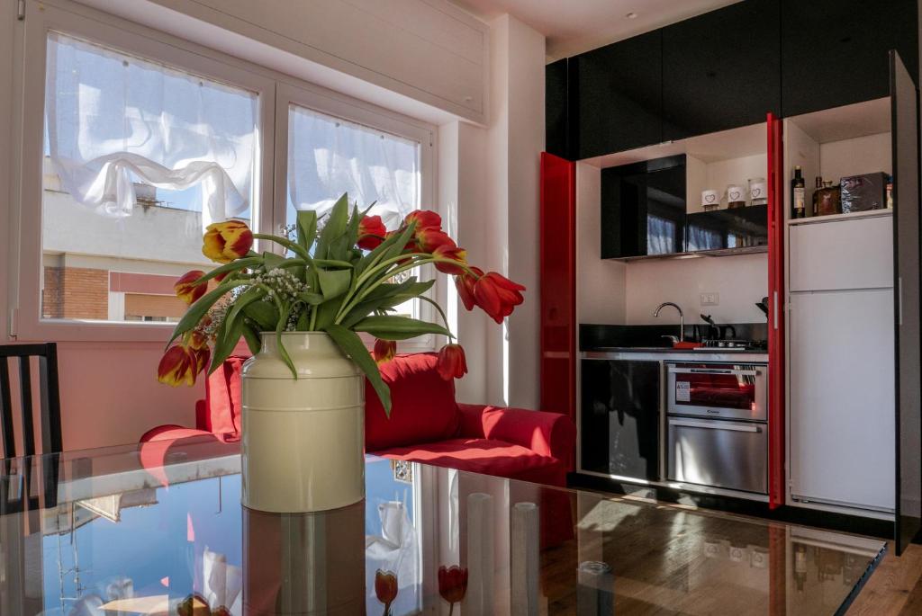 a kitchen with a glass table with a vase with flowers at Garibaldi's Camp in Rome