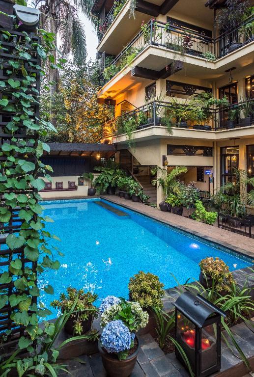 a swimming pool in the middle of a building with plants at The King Post in Nairobi
