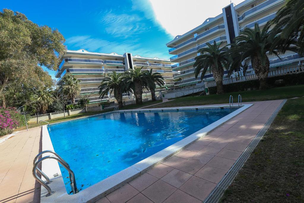a swimming pool in front of a large building at DIFFERENTFLATS Mexico in Salou