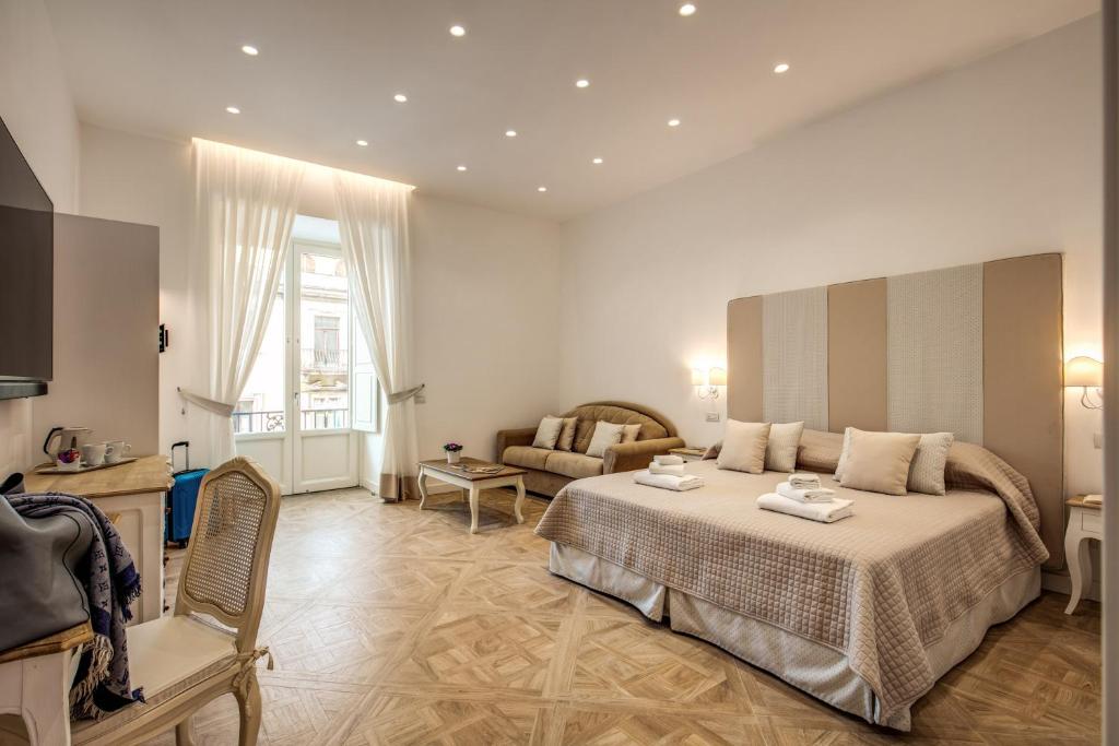 una camera d'albergo con letto e divano di Sorrento Square Suites a Sorrento