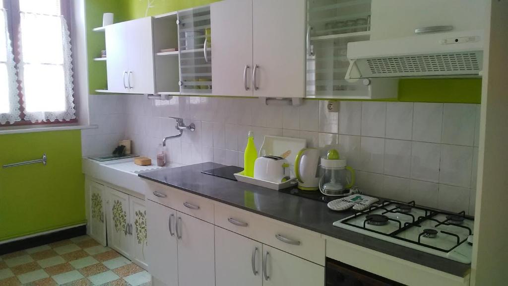 uma cozinha com armários brancos e um forno com placa de fogão em Jolie maison de Potier em Accolay