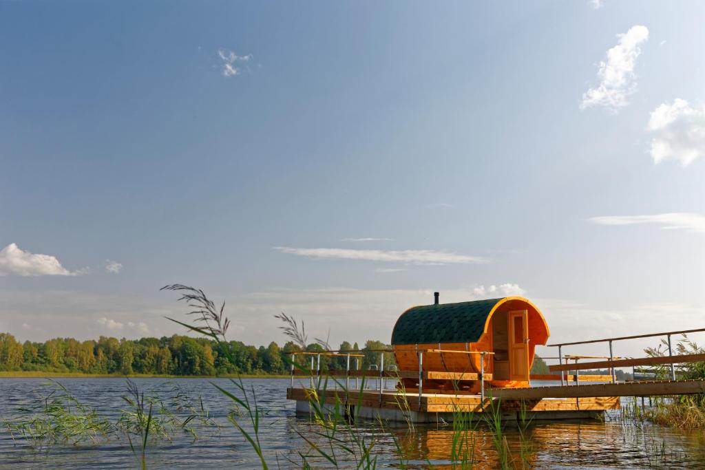 ein kleines Haus auf einem Dock auf einem See in der Unterkunft Ezermala in Valdemārpils