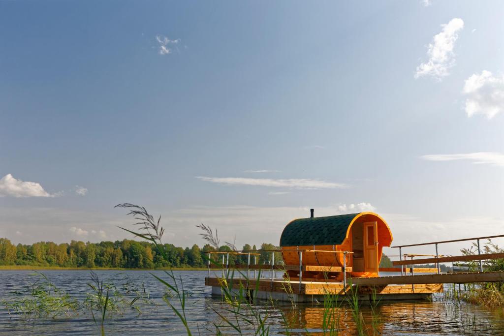 a small house on a dock on a lake at Ezermala in Valdemārpils