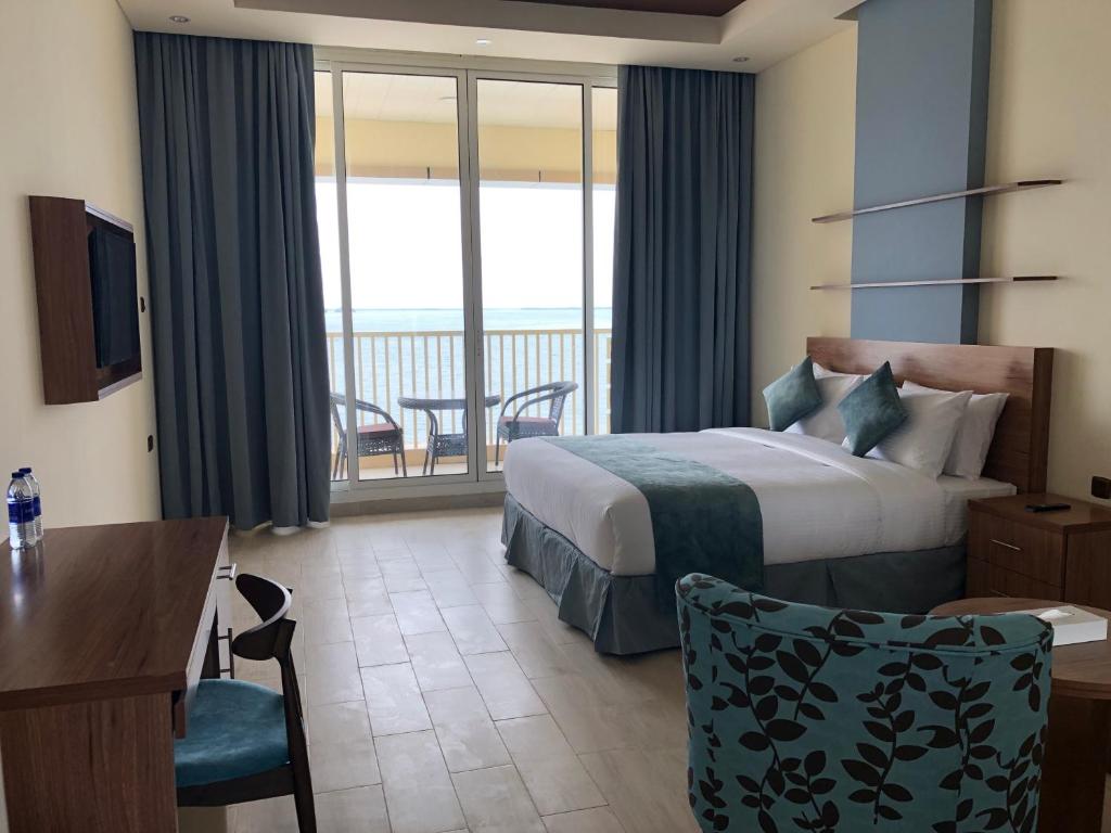 a hotel room with a bed and a balcony at Flamingo Beach Hotel in Umm Al Quwain