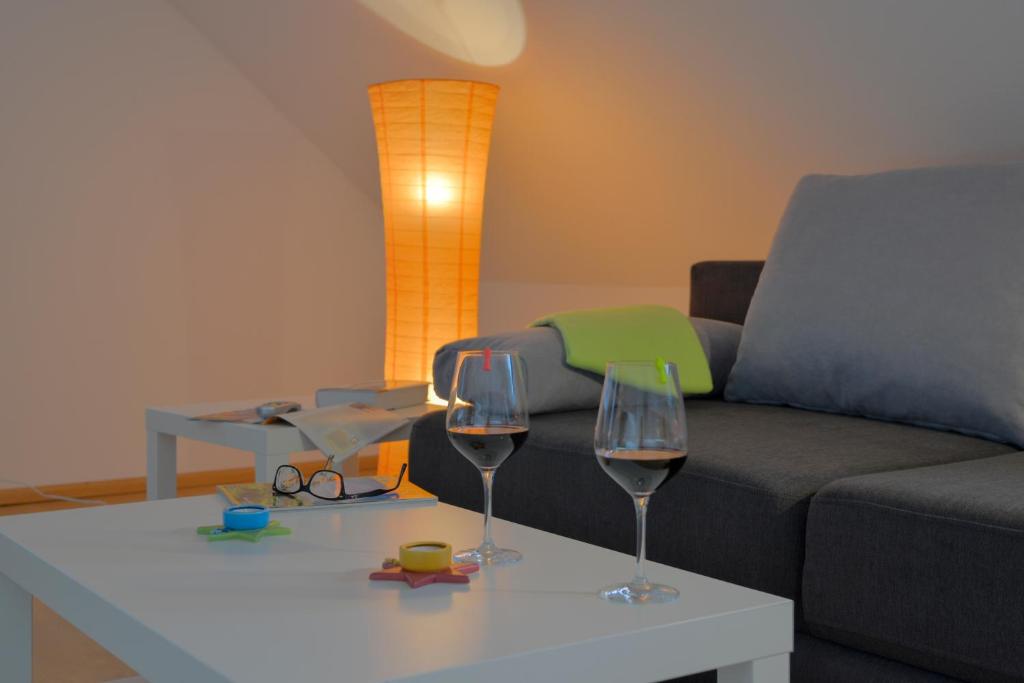 ein Wohnzimmer mit einem Sofa und zwei Weingläsern auf dem Tisch in der Unterkunft flat2let Apartment 2 in Frankfurt am Main