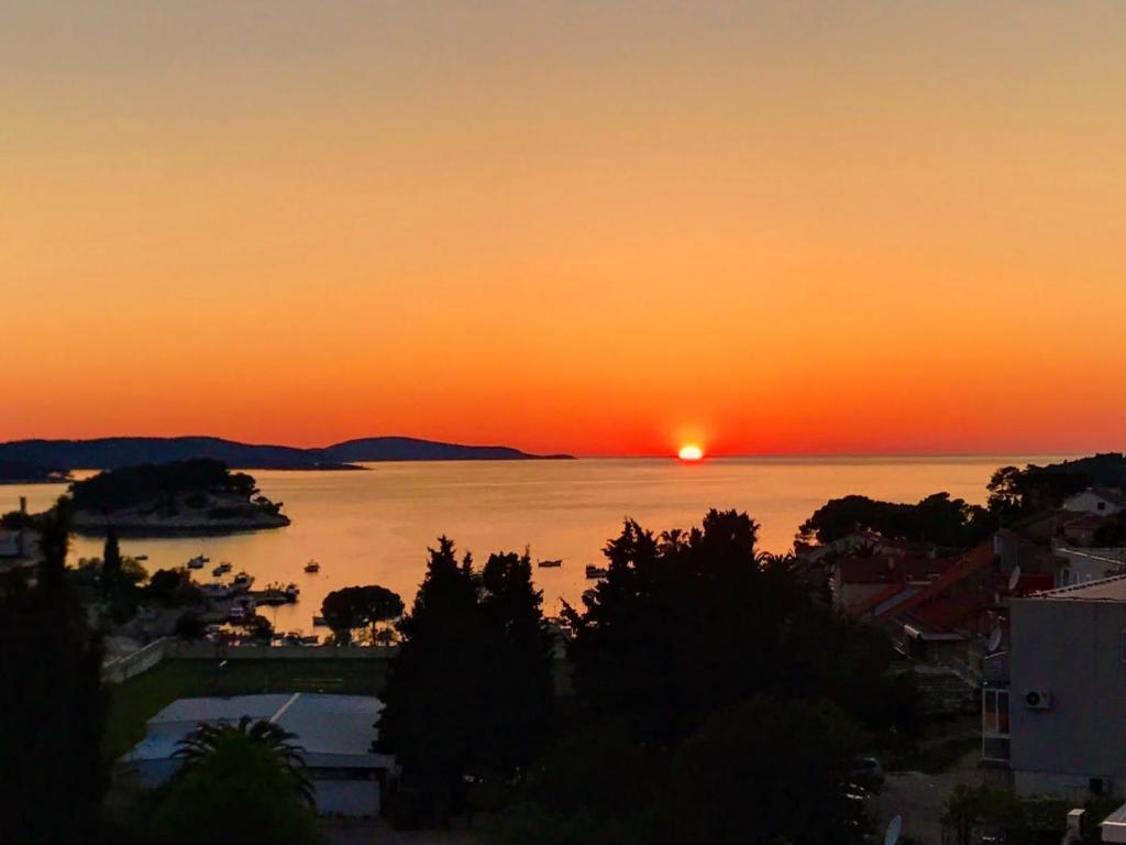 un tramonto su un corpo d'acqua con una città di Sea You Apartment a Hvar